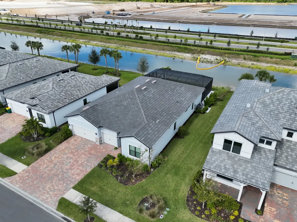 Angled aerial view of a residential roof and surrounding property