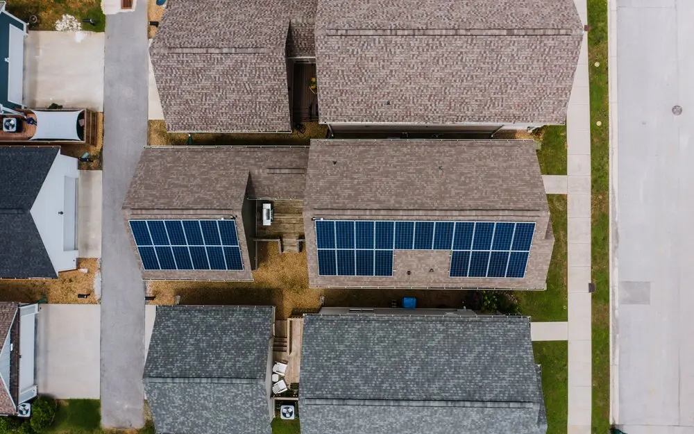 Aerial nadir view of residential rooftops with solar panel installations in a suburban neighborhood (temporary stock photo, not BlueJay footage)